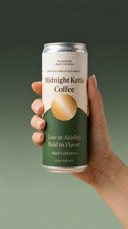 A hand holding a can of Midnight Kettle Coffee against a dark green gradient background. The can features a white top half with black text and a green bottom half with a gold coffee bean graphic.