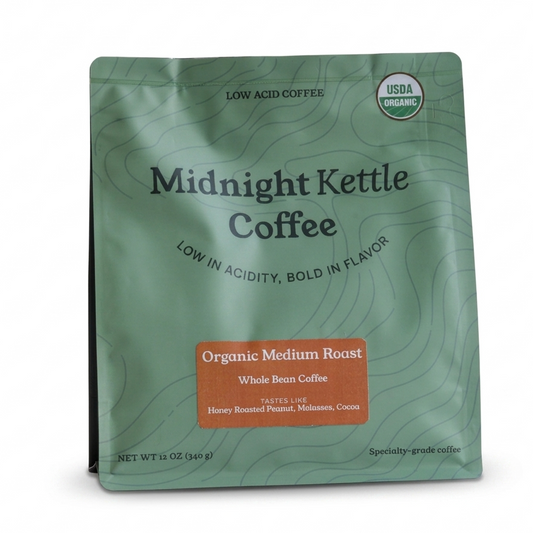 A 12 oz stand-up pouch of Midnight Kettle Coffee, Organic Medium Roast, in a sage green color with a brown label and black text, shown on a white background.
